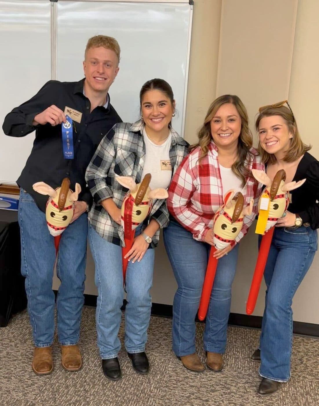JRE agents with stick horses at a rodeo-themed office day