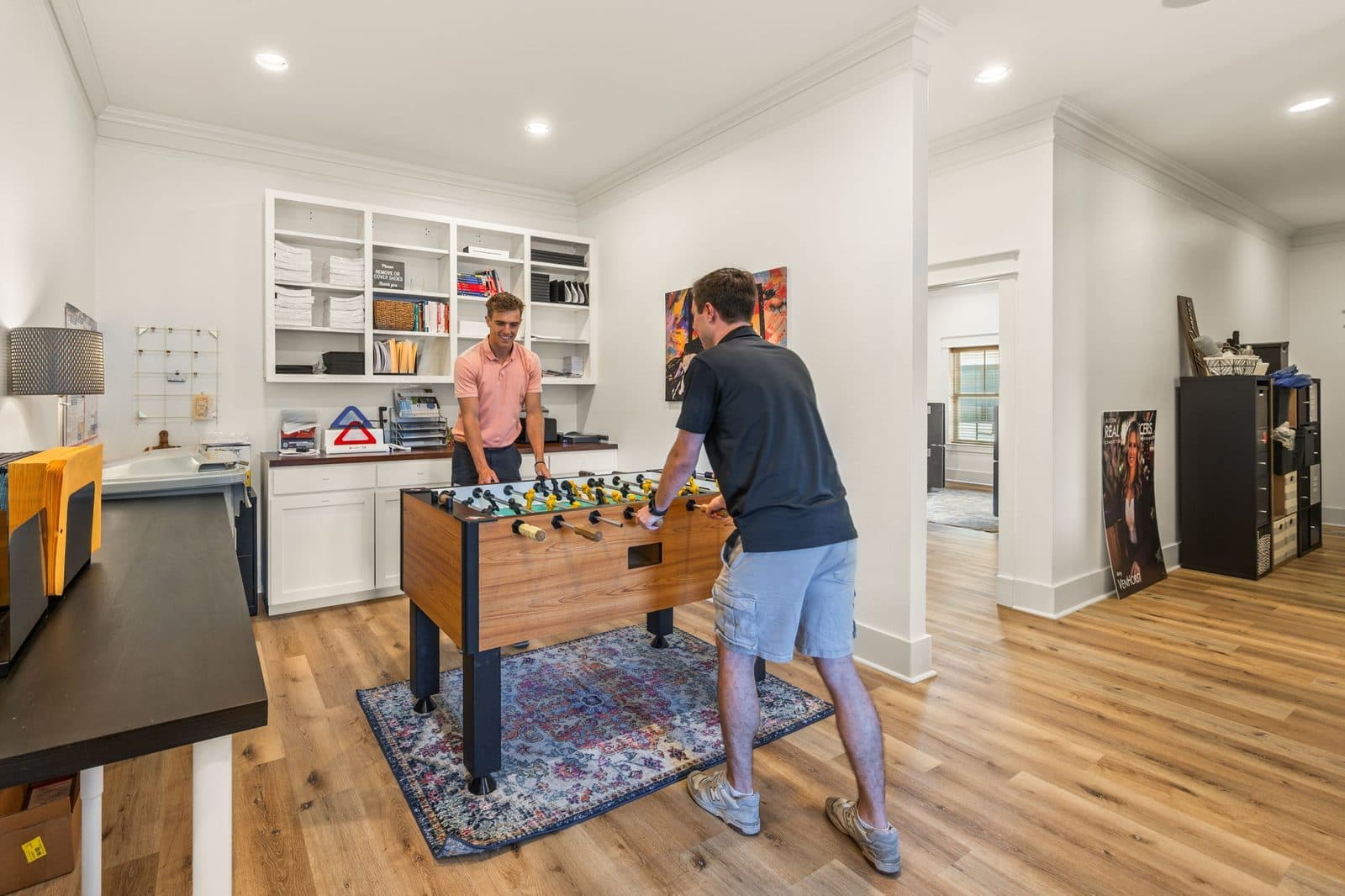 Two agents playing foosball in the break room